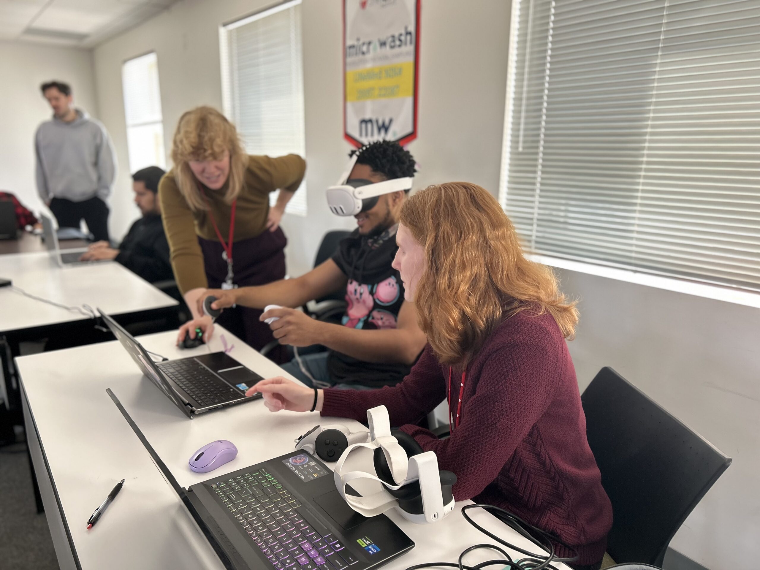 3 Ovrp team members working on a laptop, one is wearing the VR headset 