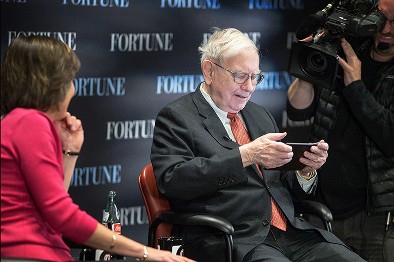 Warren Buffett poses at UNO's Mammel Hall with his donated portrait.